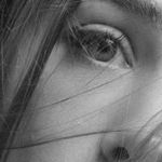 Artistic black and white close-up portrait of a woman's face, highlighting her eye and lips.